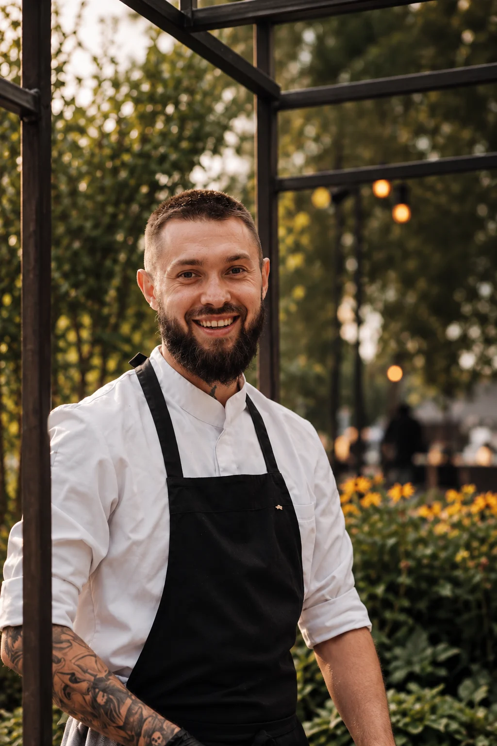 Chef Petre standing beside a table prepared with plated food.